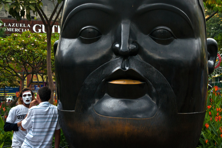 Man Leaning on Botero Sculpture Head